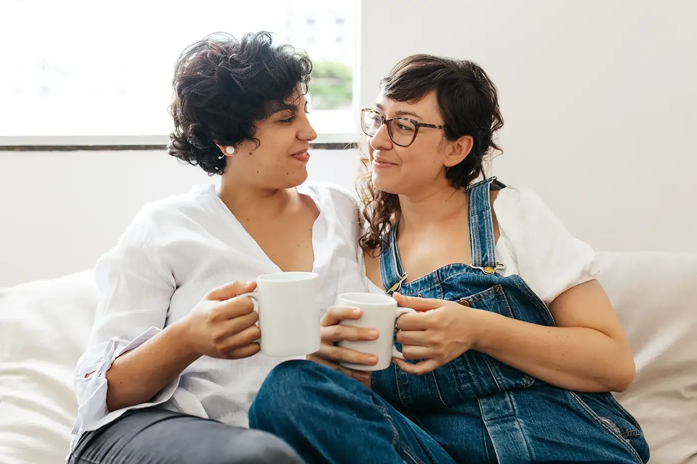 Foto de un par de mujeres sentadas juntas en el sofá.